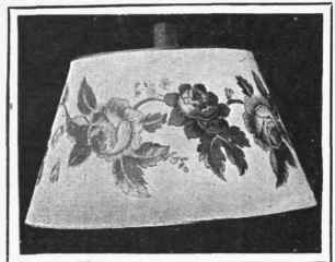 A home made lamp shade of thick cartridge paper decorated with chintz flowers
