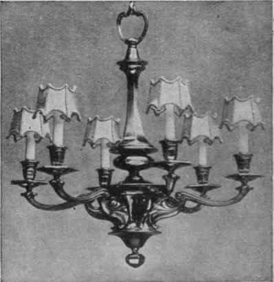 Porcelain candles can be fitted with tiny incandescent mantles or electric bulbs, and when the direct rays are broken by shades of beads or silk the effect is soft and pretty