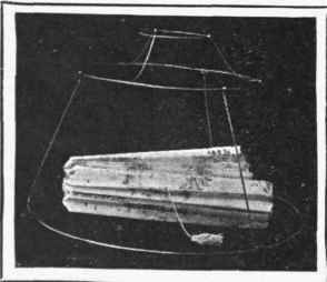 The wire frame for a home made lamp shade. Inside is shown the folded shade