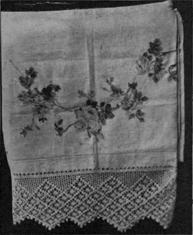 A pretty bedspread can be made by cutting out rose garlands from chintz and appliqueing them on to white linen by buttonholing round the leaves and flower;