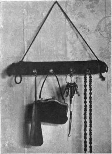 A useful  tidy formed by covering a rolling pin with black velvet and furnishing it with cup hooks, from which may be hung such articles as button hook, purse, keys, or muff chain