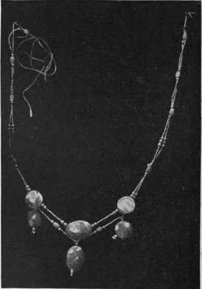 This necklet is composed of nacre plaques, tiny metallic beads, with larger glass and pearl beads