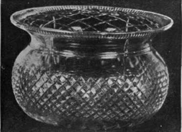 A beautiful rose bowl in English cut glass, with brass wire cover to support the flowers. These bowls look well filled with roses of any colour By permission of Messrs. Shoolbred