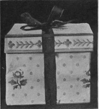 A hatbox can be made ornamental with chintz patterned wallpaper and a chou of ribbon. A large sized hat can then remain in its original case