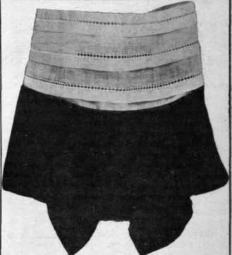 A neat design in tucked muslin and black moire silk fancy lace pin performing the same office at the throat in front.