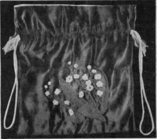 Crochet lily'of'the valley with leaves applied to a theatre bag of old gold satin