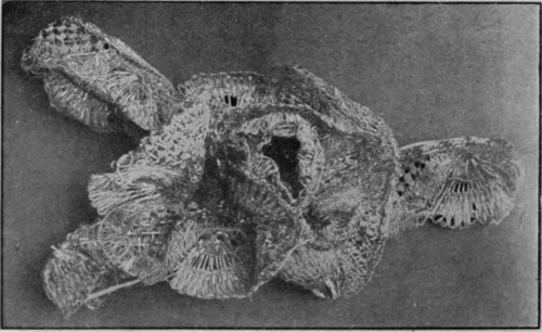 A handsome gold rose spray, in torchon lace, suitable for a toque, muff, or corsage ornament