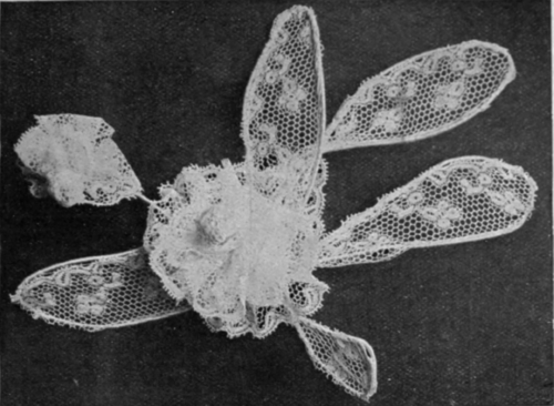 A rose spray in white thread lace for the trimming of a summer hat