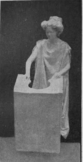 The  Bust  getting inside the pedestal, which is made from an oblong packing case covered in white paper