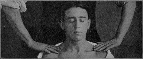 Fig. 133.   Stroking the neck: patient sitting. The end of the stroke. The back of the patient's head should rest on a pillow or towel, which, in turn, rests against the masseur's waistcoat