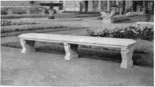 Concrete lawn bench made in imitation of granite by using white Portland cement and selected granite chips, then rubbing the whole down with carborundum stone after forms were removed.