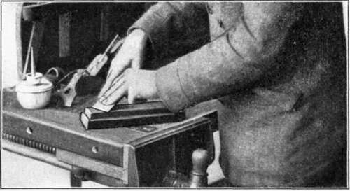 Fig. 27.   Whetting, or Oilstoning, the Beveled Side of a Cutter.