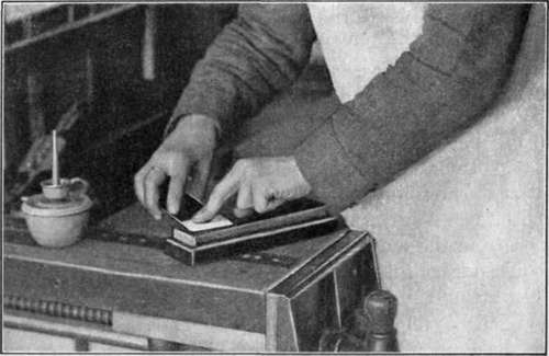Fig. 28.   Whetting, or Oilstoning, the Plain Side of the Plane Iron.