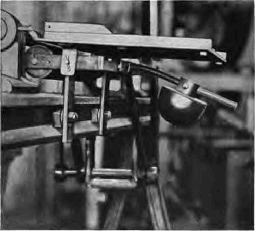Case rolling machine showing counterweighted pressure shoe.